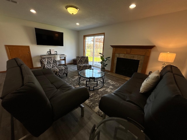 living area featuring recessed lighting, wood finished floors, and a fireplace