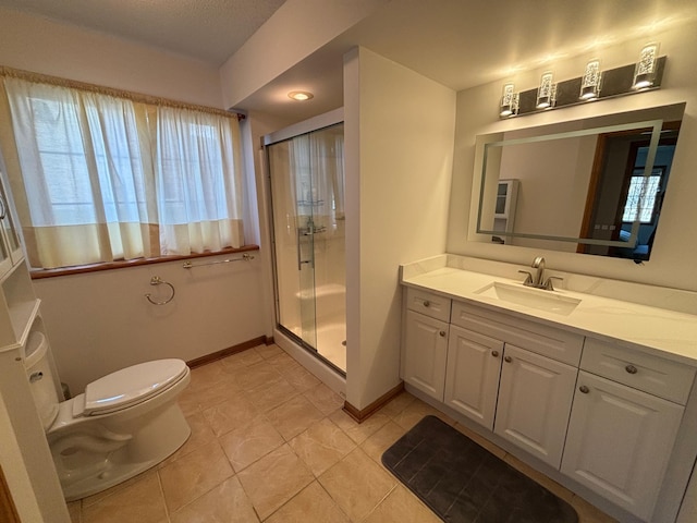 bathroom with tile patterned flooring, a stall shower, vanity, baseboards, and toilet