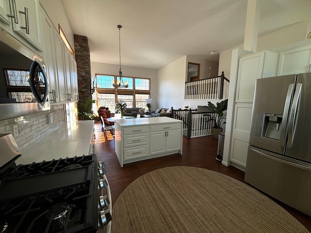kitchen with a kitchen island, white cabinetry, a chandelier, dark wood finished floors, and stainless steel appliances