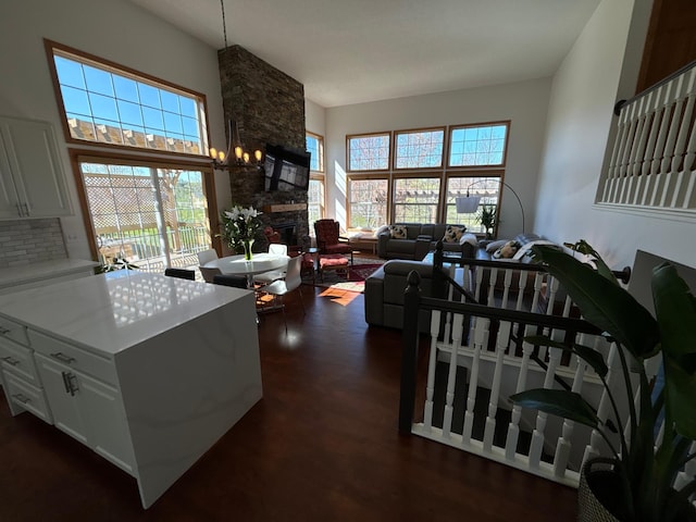 living area with a wealth of natural light, dark wood-type flooring, and a fireplace