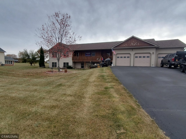 ranch-style house featuring a garage, aphalt driveway, and a front yard