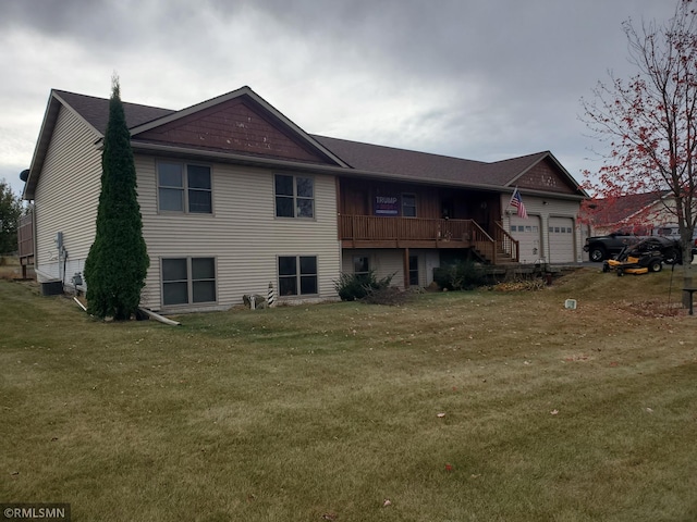 back of house with a garage and a lawn