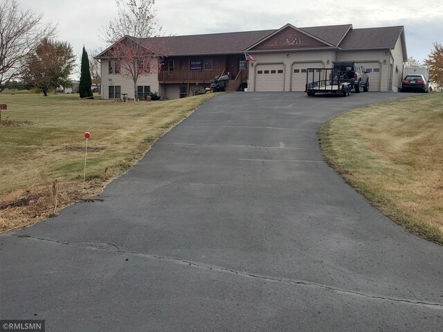view of front of property featuring a garage, a front lawn, and driveway