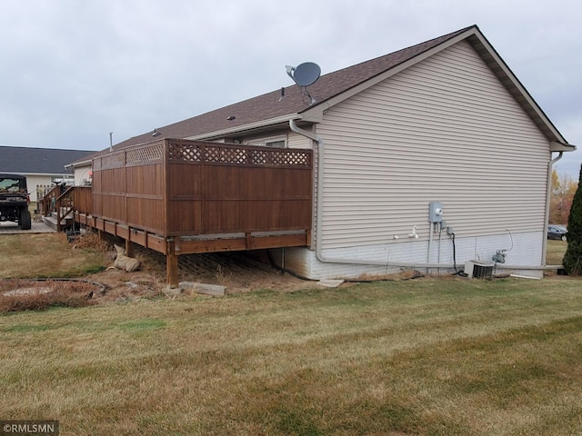 view of side of property featuring a lawn and central air condition unit