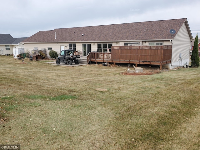 rear view of house featuring a yard and a deck