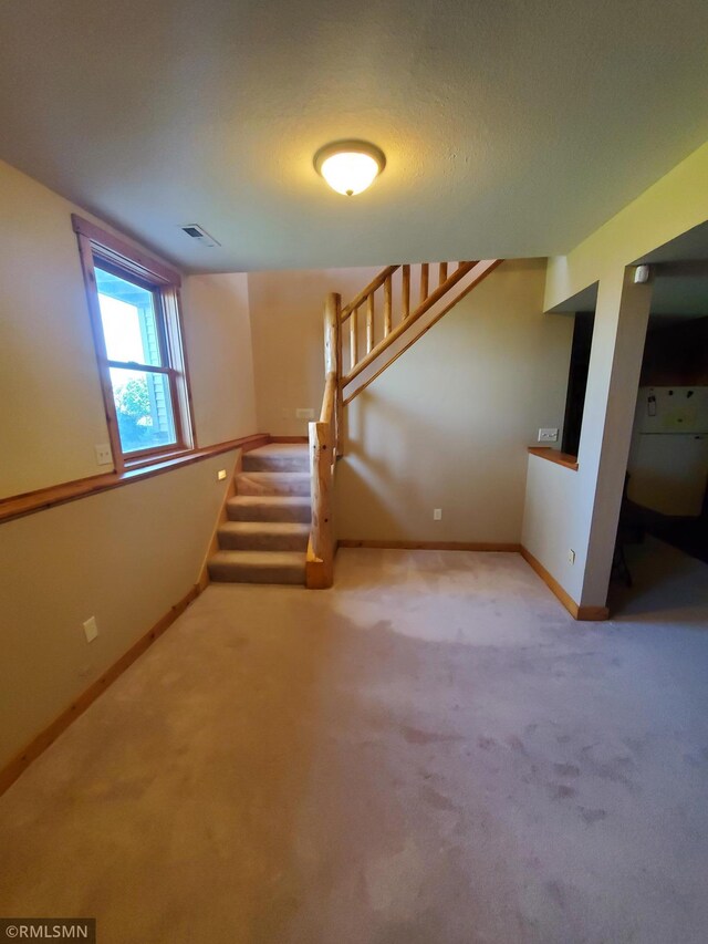 1603 86th Ave, Hammond Twp, WI 54015 - unfurnished living room featuring carpet, stairway, and baseboards