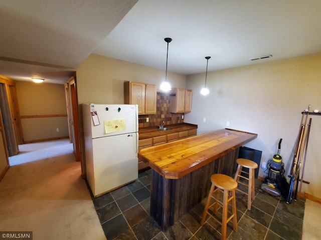 1603 86th Ave, Hammond Twp, WI 54015 - kitchen with freestanding refrigerator, butcher block counters, decorative backsplash, a breakfast bar area, and a sink