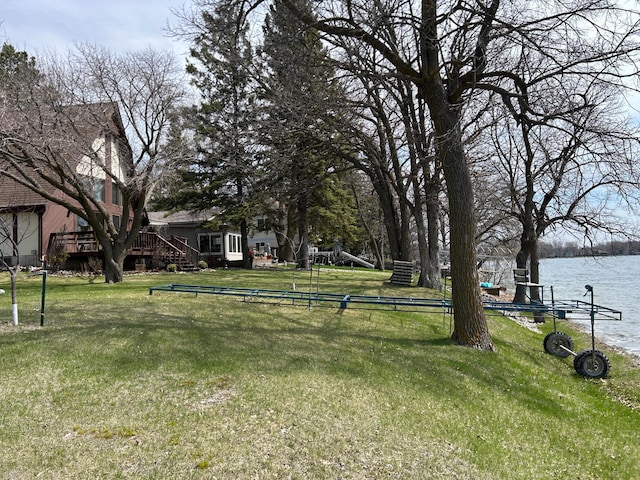 view of yard featuring a deck with water view and stairway