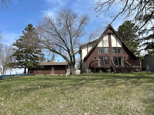 back of property with a lawn and a wooden deck