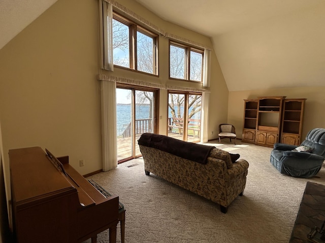 carpeted living room featuring high vaulted ceiling