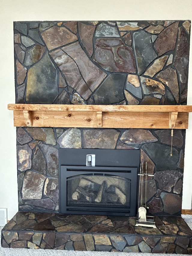 interior details featuring a stone fireplace