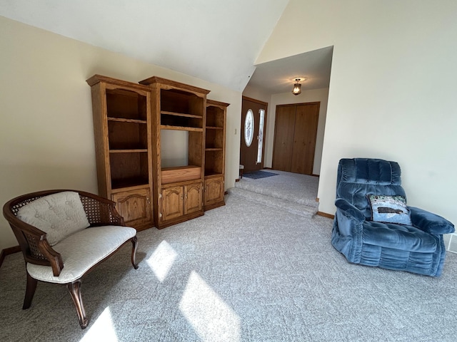living area with light colored carpet and high vaulted ceiling