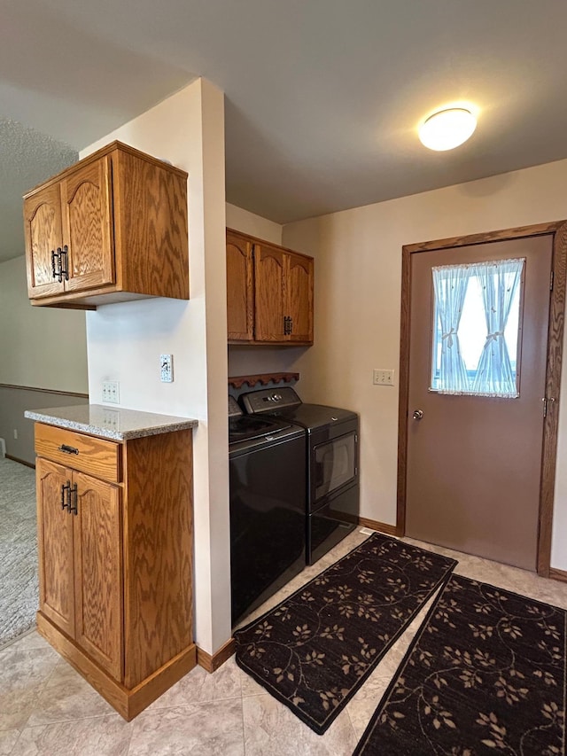 laundry room with washer and dryer, baseboards, and cabinet space