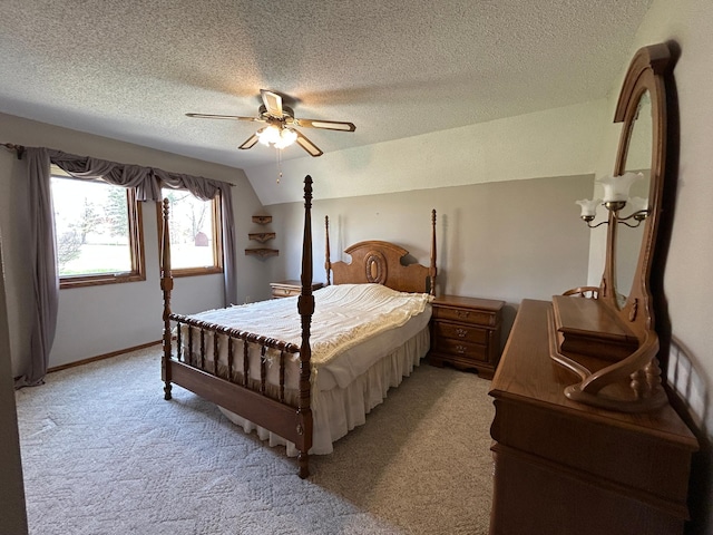 bedroom with ceiling fan, a textured ceiling, light colored carpet, vaulted ceiling, and baseboards