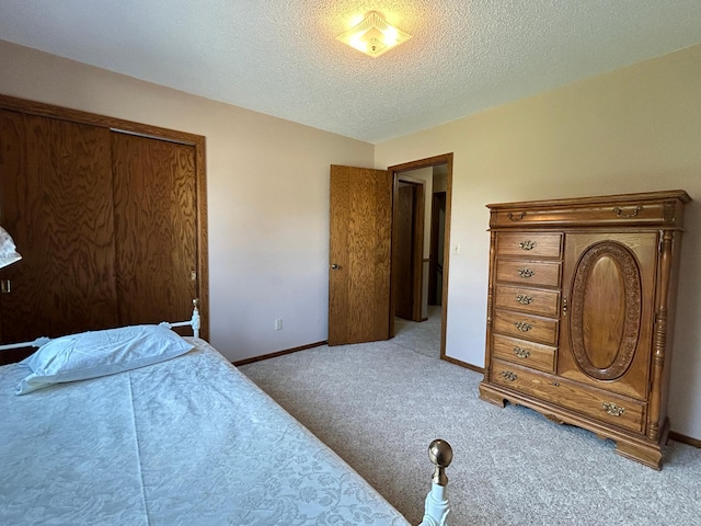 bedroom featuring carpet floors, a textured ceiling, baseboards, and a closet