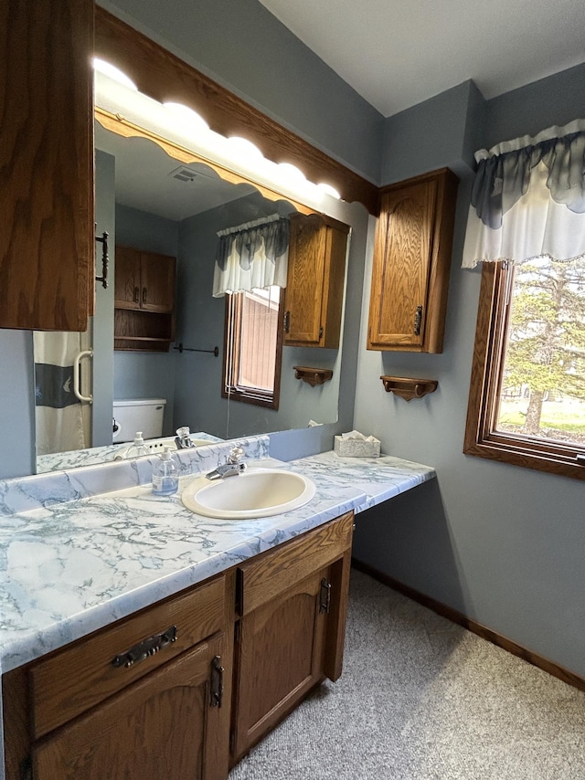 full bath with vanity, baseboards, and toilet
