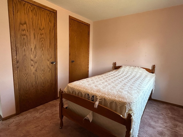 carpeted bedroom with multiple closets and baseboards