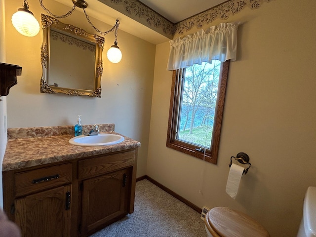 bathroom with vanity, baseboards, and toilet