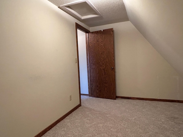 bonus room with carpet floors, baseboards, attic access, a textured ceiling, and vaulted ceiling