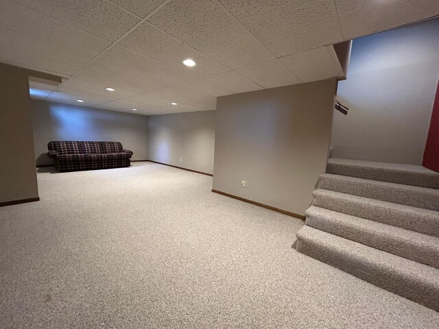finished basement with stairway, carpet floors, baseboards, a drop ceiling, and recessed lighting