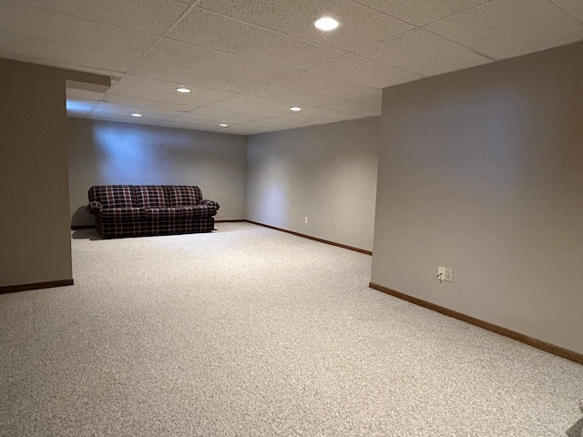 finished basement with baseboards, carpet flooring, and a paneled ceiling