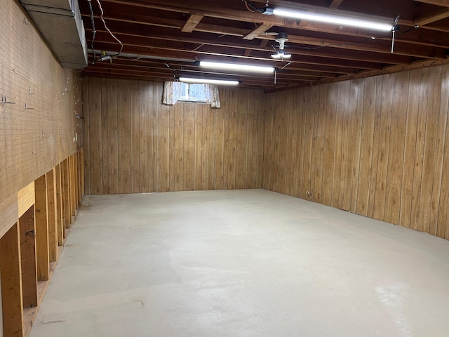 basement featuring wooden walls