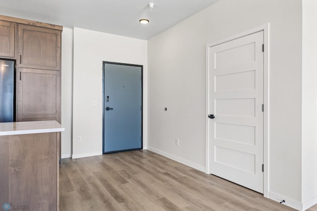 interior space featuring baseboards and light wood-style floors