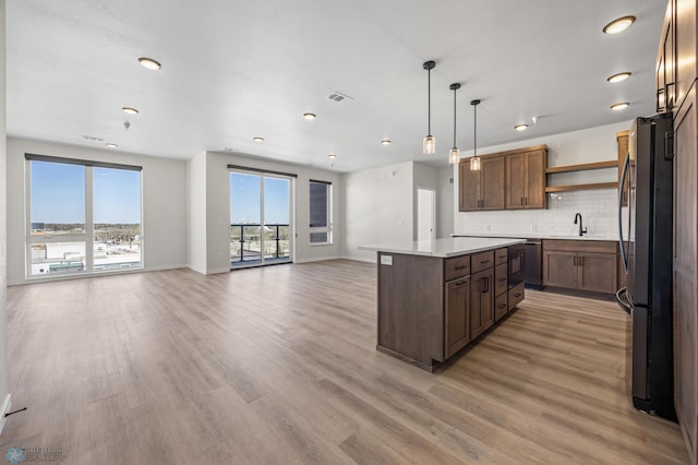 kitchen with plenty of natural light, open shelves, a sink, and appliances with stainless steel finishes