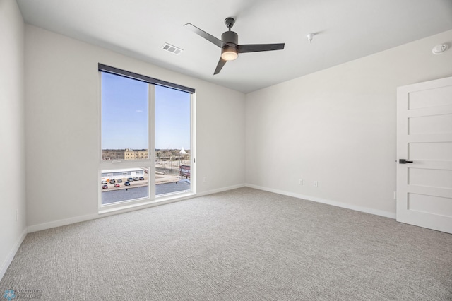 unfurnished room featuring carpet floors, baseboards, a ceiling fan, and visible vents