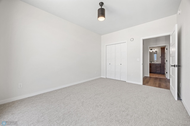 unfurnished bedroom with dark colored carpet, baseboards, and a closet