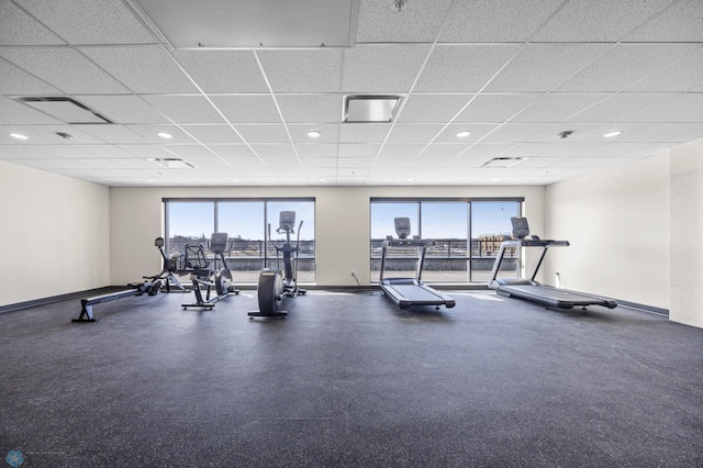 exercise room with baseboards, recessed lighting, a paneled ceiling, and visible vents