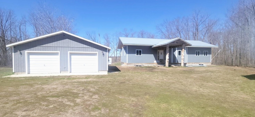 single story home featuring an outbuilding and a detached garage