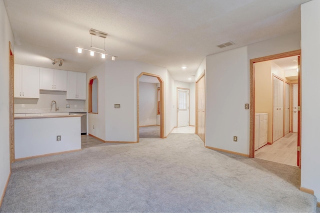 1870 Southpointe Ter Unit W1870, Eagan, MN 55122 - unfurnished living room with light carpet, a sink, arched walkways, washer / clothes dryer, and visible vents