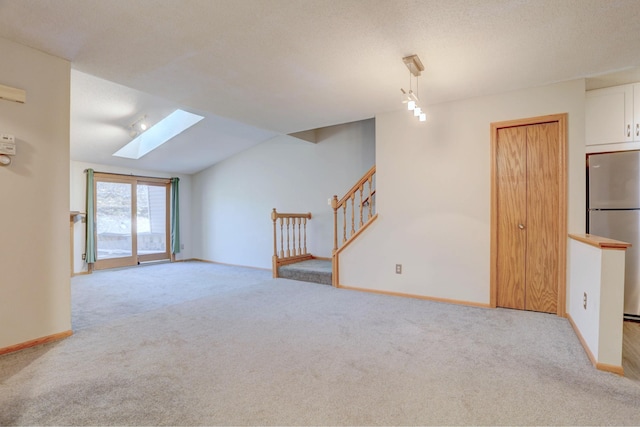1870 Southpointe Ter Unit W1870, Eagan, MN 55122 - unfurnished living room featuring carpet floors, baseboards, stairs, and vaulted ceiling with skylight