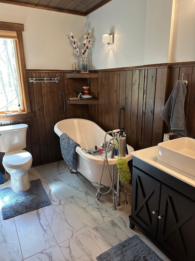 32305 W St, Breezy Point, MN 56472 - full bath featuring wainscoting, marble look tiles, wooden walls, a soaking tub, and toilet
