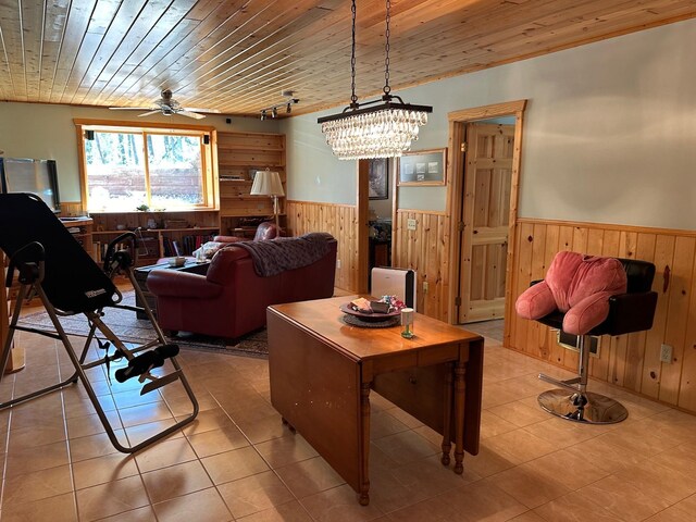 32305 W St, Breezy Point, MN 56472 - living area featuring wooden walls, a wainscoted wall, wooden ceiling, a ceiling fan, and tile patterned floors