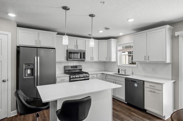 1144 Middlefield Rd, Medina, MN 55340 - kitchen featuring stainless steel appliances, a sink, white cabinetry, a center island, and a textured ceiling