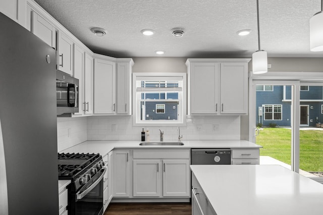 1144 Middlefield Rd, Medina, MN 55340 - kitchen with stainless steel appliances, a sink, light countertops, white cabinets, and dark wood-style flooring