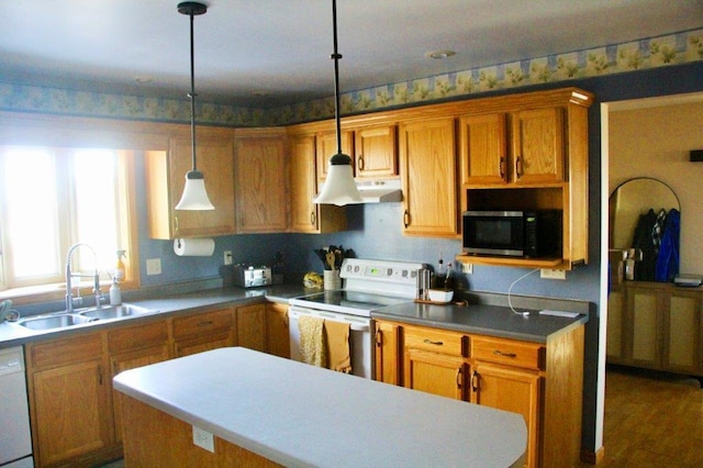 kitchen with a kitchen island, decorative light fixtures, a sink, under cabinet range hood, and white appliances
