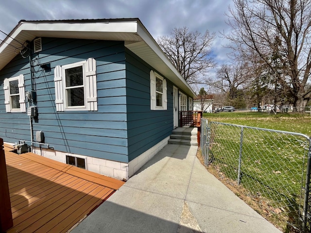 view of side of property featuring fence and a lawn