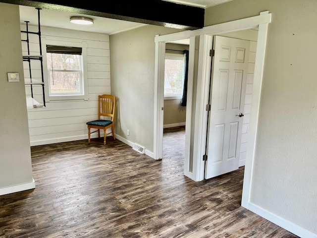 spare room featuring visible vents, ornamental molding, baseboards, and dark wood-style floors