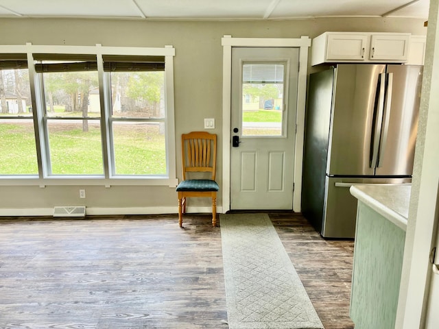 doorway featuring visible vents, a wealth of natural light, and wood finished floors