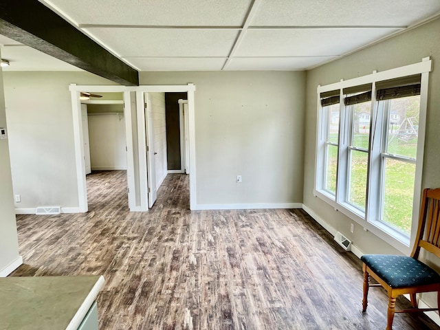 interior space featuring baseboards, wood finished floors, and visible vents