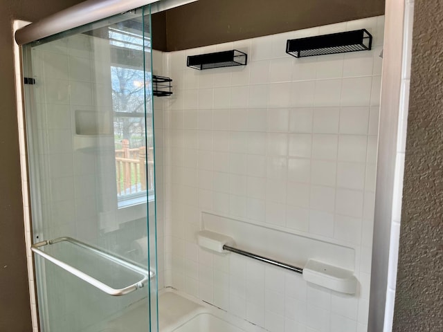 full bathroom with plenty of natural light and tiled shower