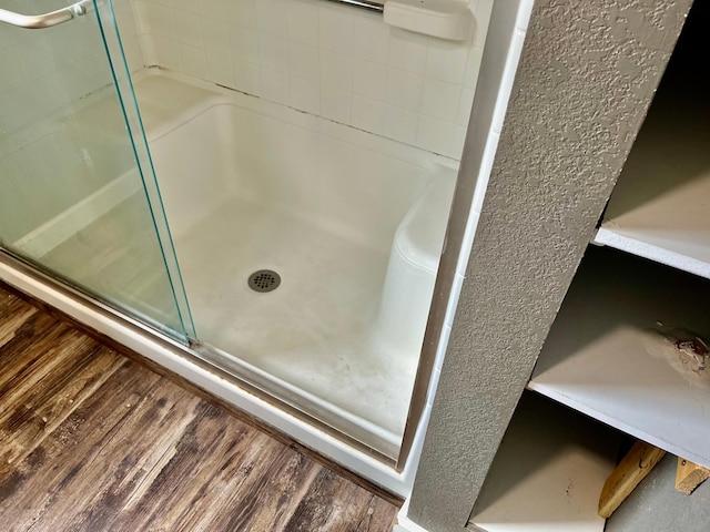 full bath with a shower with door and wood finished floors