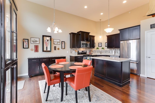 6942 151st St, Savage, MN 55378 - kitchen with stainless steel appliances, light countertops, backsplash, a chandelier, and a kitchen island