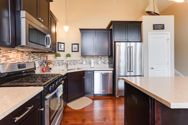 6942 151st St, Savage, MN 55378 - kitchen featuring stainless steel appliances, a sink, dark wood-style flooring, backsplash, and light stone counters