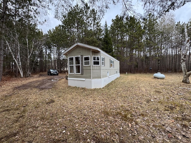 view of side of home with a wooded view