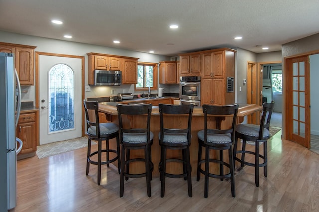 5360 Marohn Rd, Baxter, MN 56425 - kitchen featuring a kitchen breakfast bar, appliances with stainless steel finishes, french doors, and light wood finished floors