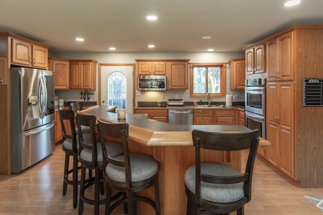 5360 Marohn Rd, Baxter, MN 56425 - kitchen featuring a sink, a breakfast bar area, stainless steel appliances, and light wood-type flooring